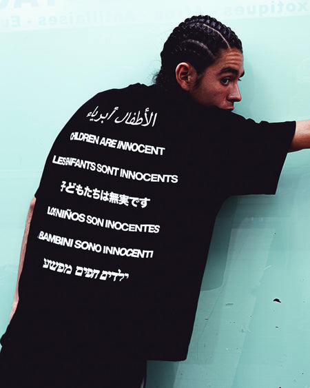 Tee-shirt noir « Children are innocent », la phrase écrite en plusieurs langues